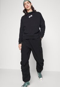 Pegador STACKED PANTS UNISEX - Calças cargo - black