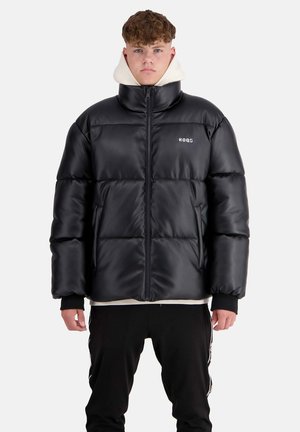 Black puffer jacket with a high collar, zip closure, and logo; features a glossy texture, oversized fit, and elastic cuffs. Worn over a white hoodie.