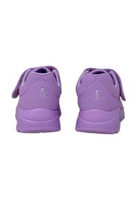 Un paio di scarpe sportive viola viste da dietro, con un logo a forma di cuore su ciascun tallone.