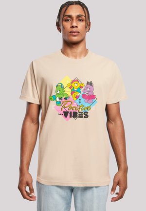 Beige cotton t-shirt featuring colorful cartoon bear graphics. Text "Positive Vibes" in bold, black font. Short sleeves and a relaxed fit.