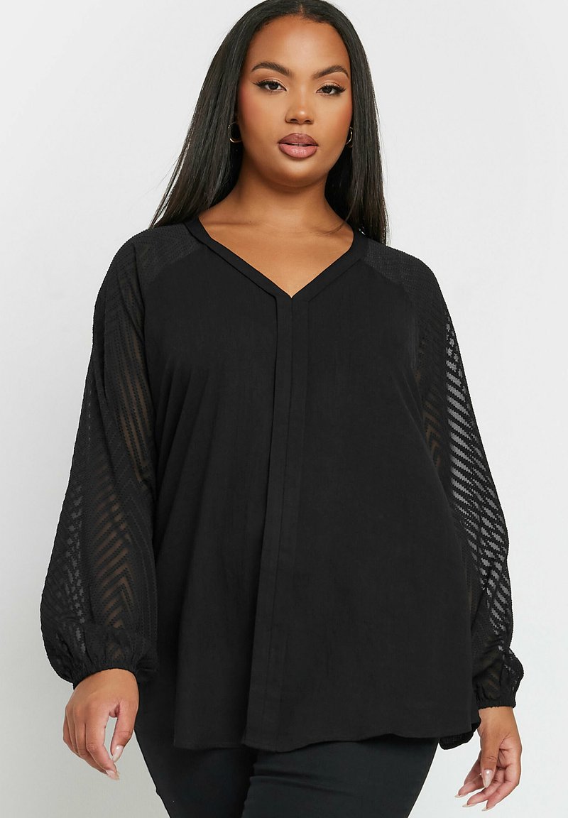 Black blouse featuring a V-neck, long textured mesh sleeves, and a relaxed fit. The fabric appears lightweight with a slight sheen.