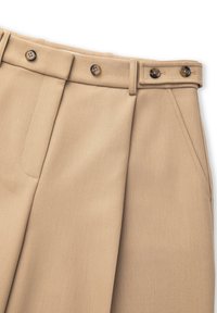 Beige geplooide broeken van soepele stof met een platte voorkant, twee zijzakken en twee bruine knopen op de tailleband.