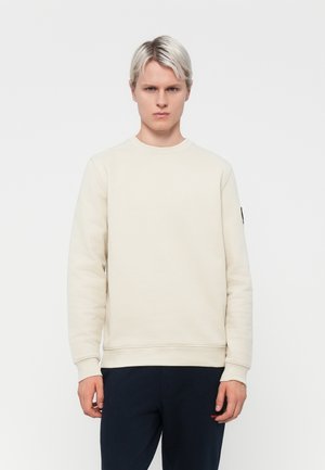 Cream colored sweatshirt with a round neck, ribbed cuffs, and a black accent on the left sleeve. Made of soft, textured fabric.
