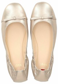 Bailarinas de cuero metálico dorado con puntera redondeada, bordes elastizados y un pequeño lazo decorativo en la parte frontal.