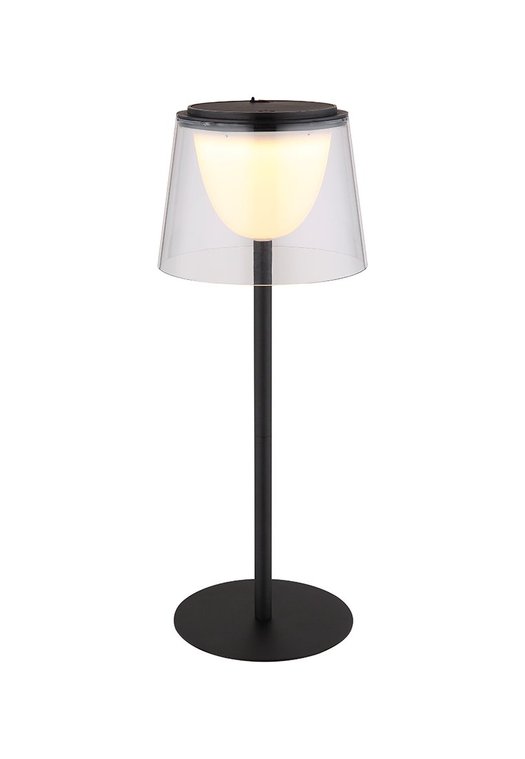 Lampada da tavolo con un paralume in acrilico trasparente, bulbo bianco e base in metallo nero; forma cilindrica con design minimalista.