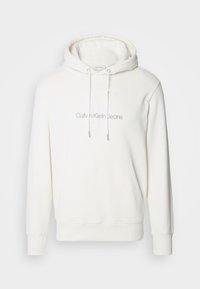 Vit bomullshoodie med dragsko i huven, framfickor i känguru-stil och broderad "Calvin Klein Jeans"-logotyp på bröstet.