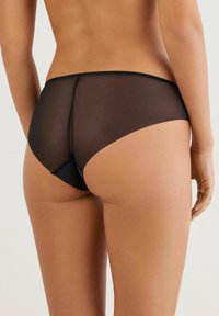 Zwarte mesh hipster slipjes met een zachte textuur, voorzien van een subtiele naaddetail aan de achterkant en een dunne elastieken tailleband.