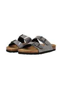 Glittriga silverfärgade slide-sandaler med två justerbara spännen, korkfotbädd och svart gummisula, som visar en minimalistisk design.