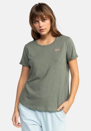Olivengrøn Roxy t-shirt lavet af blødt stof, med rund halsudskæring, korte ærmer og et lille pink logo på venstre side.
