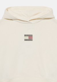 Felpa con cappuccio in tessuto crema presenta un piccolo logo multicolore con borchie nere sul petto, che mette in mostra un design geometrico.