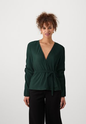 Blusa avvolgente plissettata verde con scollatura a V profonda e cintura annodata in vita, caratterizzata da maniche lunghe e una superficie texturizzata.