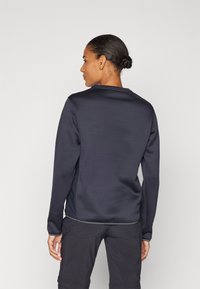 Donkerblauwe sweatshirt met een ronde hals, lange mouwen en een gestructureerde stof. Bevat contrasterende afwerking langs de zoom en de mouwen.