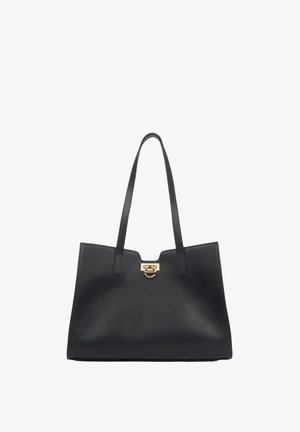 Black leather tote bag with two long handles, features a gold-tone hardware accent at the top, sleek design, smooth texture.