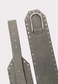 Grå læderbælte med sølvfarvede metalnitter og en rektangulær, sølvbuckle. Texturen er blød med en glat overflade.