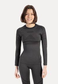 Sort atletisk langærmet top med tætsiddende pasform, sømløs tekstur og subtile geometriske mønstre på brystet og ærmerne.