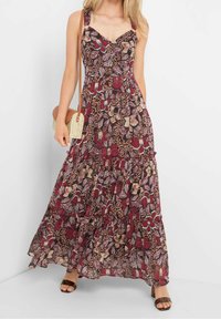Maxiklänning med blommig och bladtryck i djup burgund, med en åtsittande livstycke, justerbara axelband och lager av volangkant.