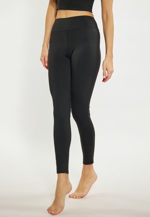Leggings neri realizzati in un materiale elastico, con una vita alta, un design elegante e dettagli di cucitura sottili.