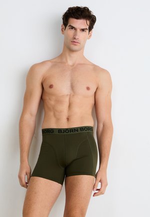 Olivgrüne Boxerbriefs mit einem schwarzen Gummibund, auf dem der Markenname "BJÖRN BORG" in einem wiederholten Muster abgedruckt ist. Glattes, enganliegendes Design.