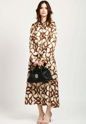 Brun og creme mønstret kjole med kraveudskæring, parret med en sort håndtaske med et karakteristisk logo og nude sandaler.