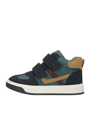 Baskets montantes pour enfant avec panneaux bleu foncé, vert, marron et beige, deux bandes velcro et semelle blanche avec crampons noirs.