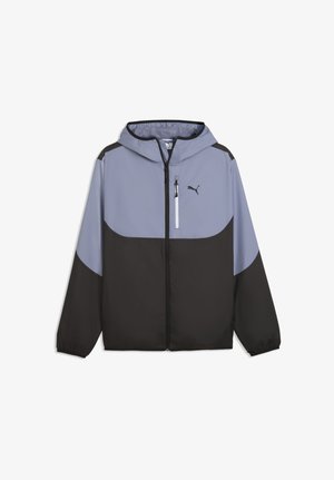 Chaqueta cortavientos con capucha, cremallera frontal, bolsillo con cremallera en el pecho y puños elásticos, en bloques de color gris claro y negro.