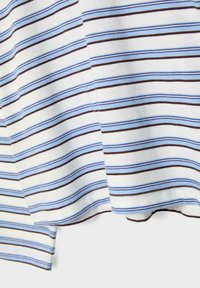 Bela tkanina s horizontalnimi tanjšimi črtami v svetlo modri in rjavi barvi, prikazuje zloženo robno šivanko in mehko teksturo.