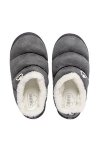 Zapatillas grises con un suave forro blanco de peluche. Forma redondeada, parte superior acolchada y suela de goma. Pequeña etiqueta de logo en el lateral.
