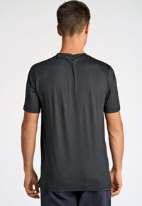 Kortärmad svart träningströja, tillverkad av lätt och andningsbart material med en slät yta, med en klassisk rund halsdesign.