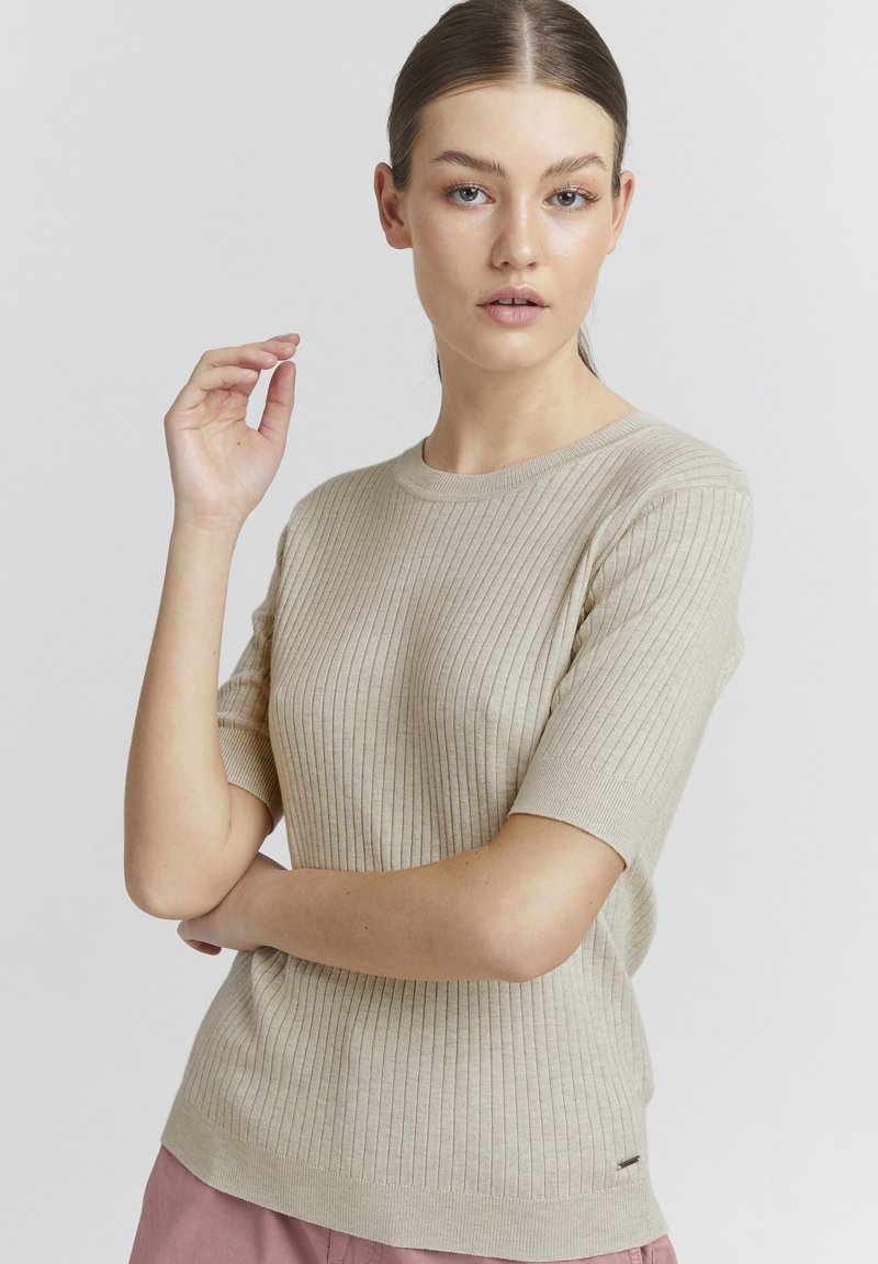 Top corto a maniche corte in maglia a coste color beige con scollatura rotonda. Presenta una silhouette aderente e una texture delicata. Etichetta logo piccola sull'orlo.