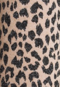 Pleteni materiál s světle růžovým pozadím, zdobený černým potiskem leopardích skvrn. Textura působí měkce a chlupatě s různými tvary skvrn.