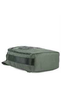 Bolsa de tela verde con forma rectangular, que presenta un panel frontal negro, cierre de cremallera y una correa. Material texturizado con patrones sutiles.