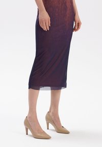 Beżowe skórzane szpilki z noskiem w szpic. Charakteryzują się gładką teksturą i smukłym, umiarkowanej wysokości obcasem.