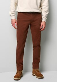 Bruine katoenen broek met een slim fit, voorzien van een gladde textuur en een klassieke vijf-pocket stijl, gecombineerd met bruine veterschoenen.