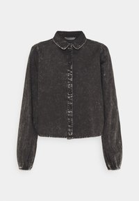 Czarna bluza z denimu z kołnierzykiem, długimi rękawami, zapięciami na guziki i postrzępionym dołem. Ma teksturowane, lekko wyblakłe wykończenie.