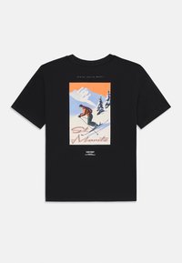 T-shirt noir en coton avec un design graphique coloré représentant un skieur devant un paysage de montagne, avec le texte "St. Moritz."