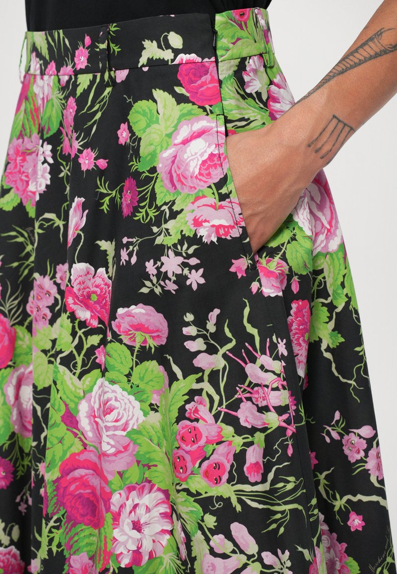 Blomstret nederdel med pink og grønne blomster på en sort baggrund, lavet af letvægtsstof, med sidelommer og en tætsiddende talje.