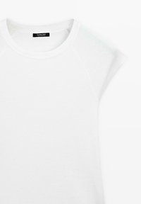 Witte T-shirt met korte mouwen en een ronde hals, met een zwart label aan de binnenkant van de kraag waarop staat "Massimo Dutti Made in Portugal."