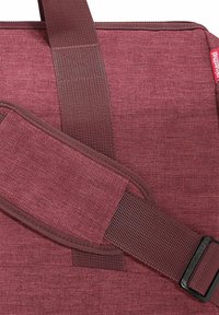 Sac en tissu bordeaux avec une finition texturée, bandoulière réglable en sangle, et une boucle noire, présentant des coutures soignées et une construction durable.