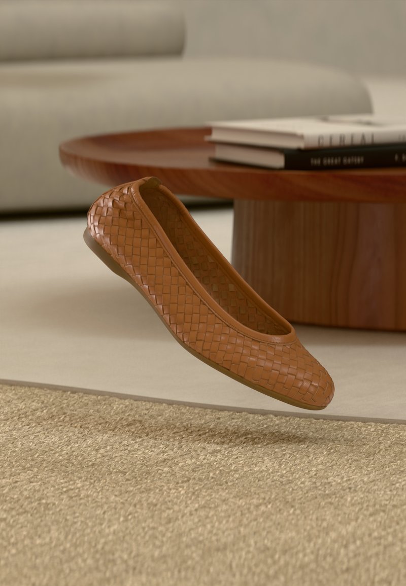 Καφέ πλεκτό δερμάτινο μπαλαρίνα με στρογγυλεμένη μύτη, λεία σόλα και υφασμάτινη υφή, τοποθετημένο σε ανοιχτόχρωμο φόντο.