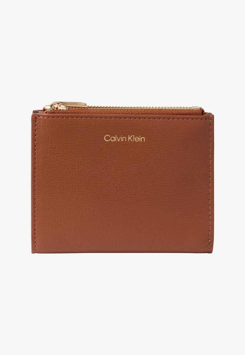 Portefeuille en cuir marron avec logo Calvin Klein doré et une fermeture éclair dorée sur le dessus.