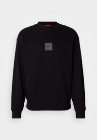 Sweat-shirt noir à manches longues et col rond, avec poignets et ourlet côtelés, arborant un petit logo carré gris au centre de la poitrine.