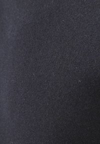 Nahaufnahme eines dunkelblauen Strickstoffs, der die detaillierte Textur und das feine Nähmuster zeigt.