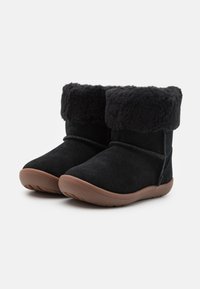 Bottines noires en suède avec un doux revers en fausse fourrure, semelle en caoutchouc et couture le long des côtés.