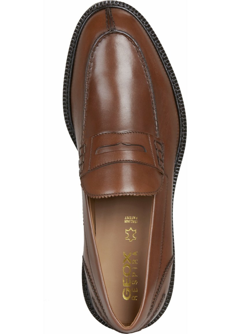 Brązowe skórzane lordsy z łatwym zakładaniem, z dekoracyjnym paskiem, zaokrąglonym noskiem i teksturowaną gumową podeszwą. Złote logo w środku.