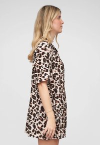 Abito stampa leopardata con maniche corte, vestibilità comoda, tessuto leggero e scollatura rotonda. I colori includono beige, marrone e nero.