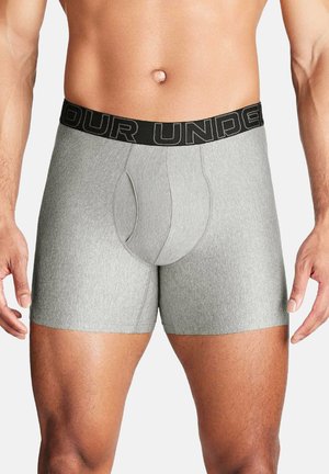 Męski tors w szarych bokserkach z czarną elastyczną gumą w pasie z częściowym tekstem marki.