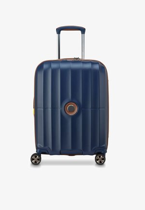 Valigia rigida blu navy con finitura testurizzata, dettagli marroni, maniglia superiore e quattro ruote per una facile manovrabilità.