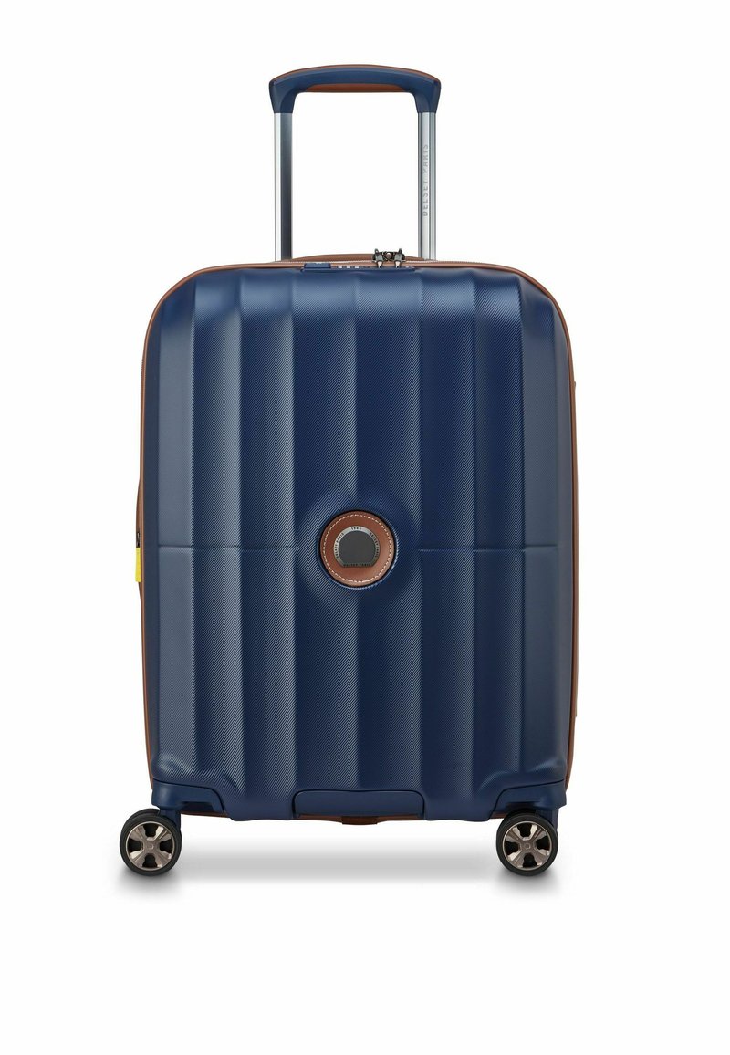Valigia rigida blu navy con finitura testurizzata, dettagli marroni, maniglia superiore e quattro ruote per una facile manovrabilità.