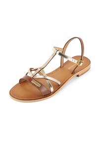 Sandalia marrón y dorada metálica con correas entrelazadas, suela plana y cierre de hebilla. Textura de cuero suave y detalles de costura.