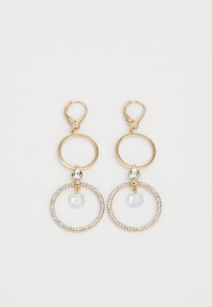 Brincos em tom dourado com argolas circulares, apresentando uma gota de cristal transparente e uma moldura de pequenas pedras claras. Fecho de alavanca.